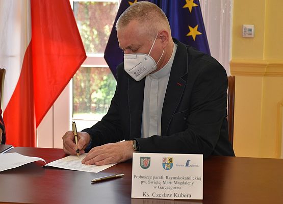 ks.Czesław Kubera podpisuje