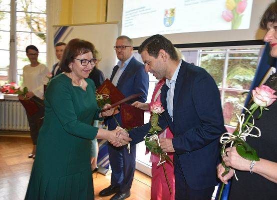 Starosta wręczająca kwiat