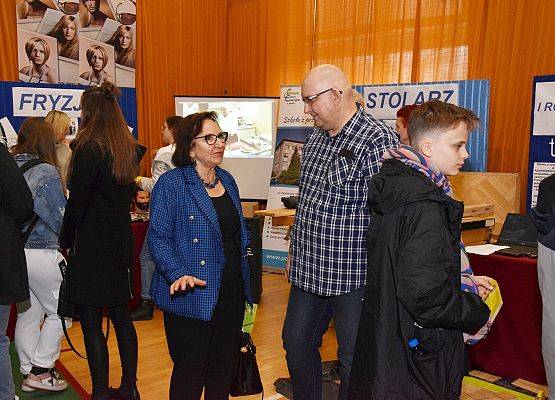 Rozmowy przy stoisku szkół