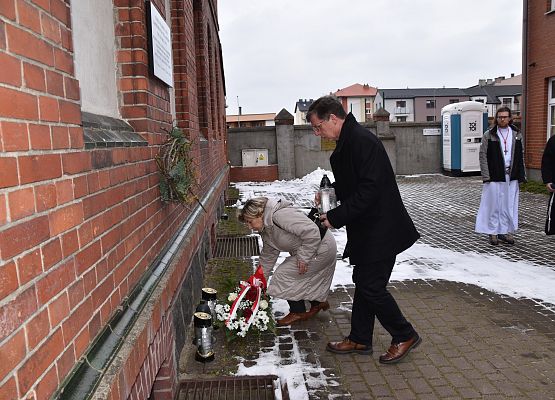 Kwiaty i znicz składają