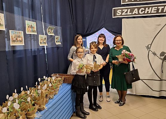 Uczniowie rozdający roślinki w